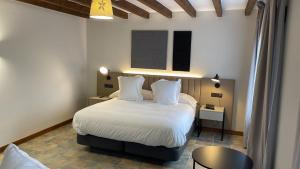 4US RIOJA WINE HOTEL في سينيسيرو: غرفة نوم بسرير وملاءات بيضاء وطاولة