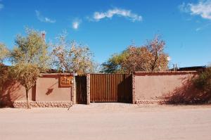 a fence with a gate in front of a building at Hostal Elim in San Pedro de Atacama