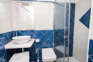 ein blau-weißes Bad mit einem WC und einem Waschbecken in der Unterkunft Moon'n Sea in Minori