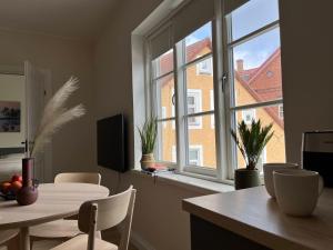 una sala da pranzo con tavolo e una grande finestra di Castle Hills Residence a Viljandi