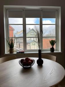 uma mesa com uma tigela de fruta em frente a uma janela em Castle Hills Residence em Viljandi