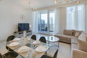 a living room with a table and chairs and a couch at Harbour Gate 1 - 2BR Apartment - Allsopp&Allsopp in Dubai