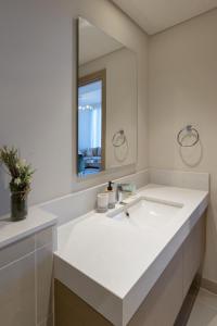 a white bathroom with a sink and a mirror at Harbour Gate 1 - 2BR Apartment - Allsopp&Allsopp in Dubai