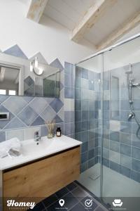 y baño con lavabo y ducha acristalada. en Borgo dei Fiori - Homey Experience, en Cugnana