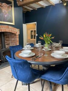 comedor con mesa de madera y sillas azules en Hurdley House-Georgian Town House, en Montgomery