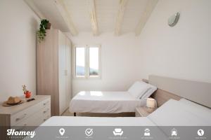 1 dormitorio blanco con 2 camas y ventana en Borgo dei Fiori - Homey Experience, en Cugnana