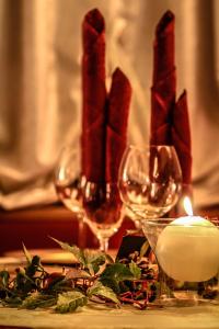 a candle and two wine glasses on a table at Hotel Aurora in Vallarsa