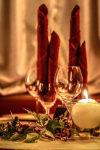 una vela y dos copas de vino en una mesa en Hotel Aurora, en Vallarsa
