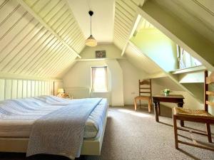 een slaapkamer met een bed en een bureau op zolder bij Vakantiehuis 't Boerderietje in Koudekerke