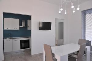 ein Esszimmer mit einem weißen Tisch und einer Küche in der Unterkunft Villa Rachele in Sant'Isidoro