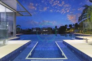 uma piscina com vista para um edifício em ZenLux: 4BR Bayview Mansion Infinity Pool + Cinema em Stuart Park