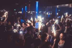 a crowd of people holding sparklers in their hands at Lodge Hôtel & Spa Les Voiles du Grand Large in Meyzieu