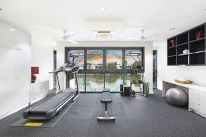 uma sala de fitness com uma passadeira e um ginásio em ZenLux: 4BR Bayview Mansion Infinity Pool + Cinema em Stuart Park