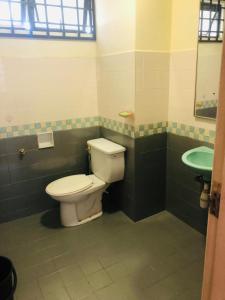 y baño con aseo y lavamanos. en PUTRI HOMESTAY SEAVIEW PD, en Port Dickson