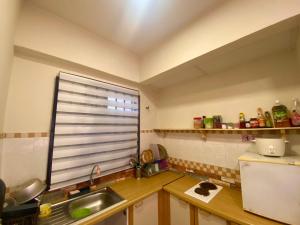 una pequeña cocina con fregadero y ventana en PUTRI HOMESTAY SEAVIEW PD, en Port Dickson