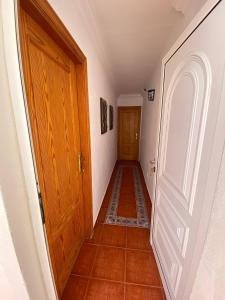 a hallway with a wooden door and a tile floor at Cosy twin beds El Galeon in Santa Cruz de Tenerife