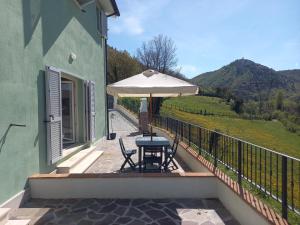 a patio with a table and an umbrella on a balcony at Casaletto Santo Spirito in Labro Rieti