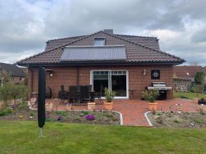 a brick house with a metal roof with a patio at Privatzimmer Guhl in Munster im Heidekreis