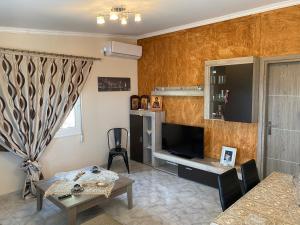 a living room with a television and a table at Three islands in Megara