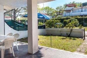 eine Terrasse mit einem Tisch, Stühlen und einem Sonnenschirm in der Unterkunft M049 - Marcelli, trilocale con giardino a 200 metri dal mare in Marcelli