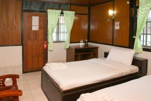 1 dormitorio con 2 camas, mesa y silla en Haadrin Resort, en Haad Rin