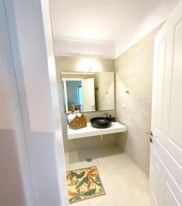 bagno con lavandino e specchio di Beachfront 4-bed luxury suite - Agios Gordios, Corfu, Greece ad Agios Gordios