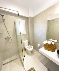 a bathroom with a shower and a toilet and a sink at Beachfront 4-bed luxury suite - Agios Gordios, Corfu, Greece in Agios Gordios