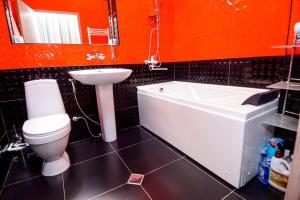 a bathroom with a toilet and a tub and a sink at Check Inn Tbilisi in Tbilisi City +53 photos