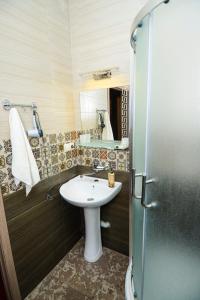 uma casa de banho com um lavatório branco e um chuveiro em Check Inn Tbilisi em Tbilisi