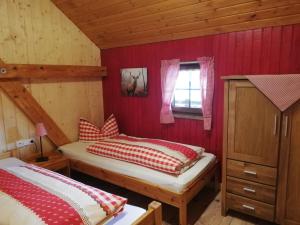Ce lit se trouve dans une chambre dotée de murs rouges et d'une fenêtre. dans l'établissement Haberjockelshof Erlebnishof, à Titisee-Neustadt
