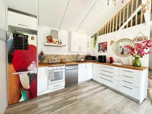 a kitchen with white cabinets and a refrigerator at Tiny House Teresa in Pontons