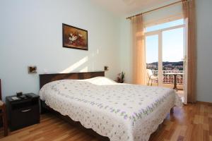 Un dormitorio con una cama y una ventana grande. en Guesthouse Victoria, en Dubrovnik