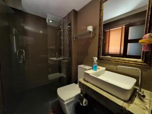 a bathroom with a sink and a toilet and a mirror at Nordwind Hotel in Chiang Mai