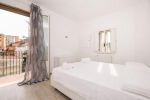 - une chambre blanche avec un grand lit et une fenêtre dans l'établissement [Conte Verde Apartment], à Campobasso