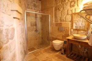 Vita Cave Suites في أوروغوب: حمام مع دش ومرحاض ومغسلة