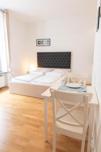 a bedroom with a bed and a table and a chair at Charming Apartments Frankfurt City in Frankfurt