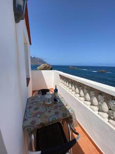 una mesa y sillas en un balcón con vistas al océano en Room in Lodge - Beautiful Sunsets from the Balcony El Roque, en Santa Cruz de Tenerife