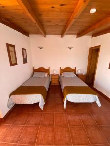 2 camas en una habitación con techos de madera en Room in Lodge - Beautiful Sunsets from the Balcony El Roque, en Santa Cruz de Tenerife