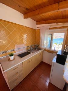 a kitchen with a sink and a refrigerator and a window at Room in Lodge - Beautiful Sunsets from the Balcony El Roque in Santa Cruz de Tenerife