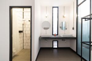 a bathroom with two sinks and two mirrors at Ombra House No. 21-24 in Chiang Mai