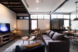 a living room with a couch and a tv at Ombra House No. 21-24 in Chiang Mai