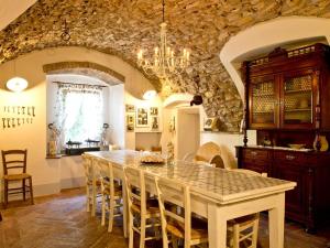 eine Küche mit einem Tisch, Stühlen und einer Steinmauer in der Unterkunft B&B Casa del Nonno in Adrara San Rocco