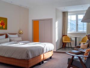 a bedroom with a large bed and a chair at The Townhouse Ruhpolding in Ruhpolding