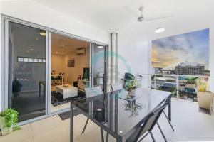 a dining room with a glass table and a large window at ZEN Central Bliss 2BR Holiday Retreat in the CBD in Darwin