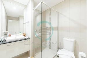 a bathroom with a shower and a toilet and a sink at ZEN Central Bliss 2BR Holiday Retreat in the CBD in Darwin +33 photos
