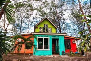 a colorful house in the middle of a forest at Villa Uda @ SIBLINGS Cottage in Setiu