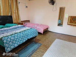 a room with two beds and a rug at Villa Uda @ SIBLINGS Cottage in Setiu