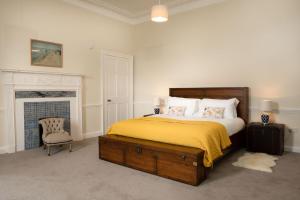 een slaapkamer met een bed en een stoel en een open haard bij Kincraig House - Seasgair Lodges in Kincraig