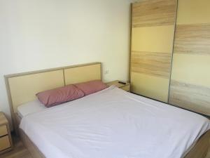 1 dormitorio con cama blanca y almohada rosa en AMA, en Timisoara