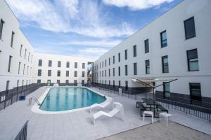 a swimming pool in front of a building at Micampus Alicante in San Vicente del Raspeig